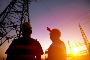 two worker watching the power tower and substation